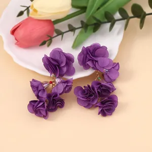 Böhmische lila Stoffblumen-Ohrringe mit bunten Perlen auf einem dekorativen Tablett