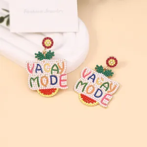 Macro shot of colorful beaded earrings with VACAY MODE text detail and handmade beads