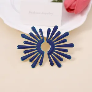 Orecchini a ala in smalto blu con bordi dorati mostrati in un set elegante