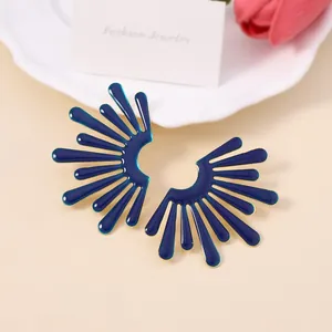 Dettaglio dei orecchini a forma di ala in smalto blu scuro con bordi dorati su ceramica