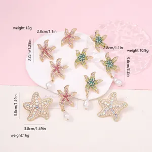 Detailed view of starfish earrings with pink rhinestones and white pearls on gold base