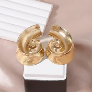 Vintage golden spiral shell stud earrings with textured finish for beach vacations