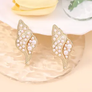 Detailed close-up of vintage shell-shaped earrings with faux pearls and gold alloy base