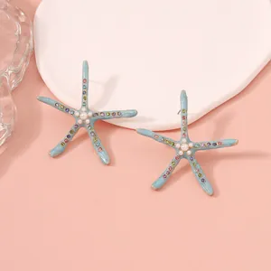 Detail view of starfish stud earrings with blue enamel, colorful rhinestones and pearl