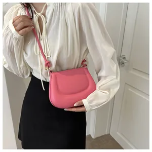 Dettaglio di una borsa a tracolla rosa brillante con design ondulato e tracolla annodata