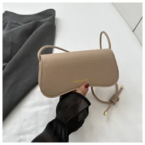 Detailed macro view of beige faux leather handbag featuring crocodile skin embossed texture