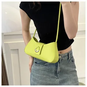 Detailed view of lime green crescent shoulder bag with golden round buckle and smooth finish