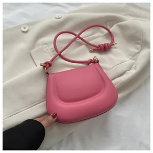 Dettaglio della borsa a tracolla rosa rosa con trama in pelle opaca e dettagli dorati