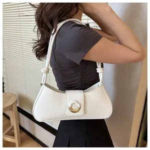 Detailed side view of a white crescent shoulder bag with golden ring and knotted strap