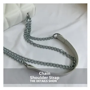 Detailopname van witte gewatteerde tas met zilveren metalen ketting schouderband