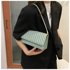 Detail view of mint green pleated PU leather shoulder bag with gold metal hardware buckle
