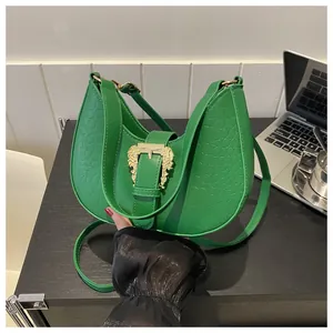 Detail of green hobo bag featuring crocodile pattern and vintage baroque gold buckle