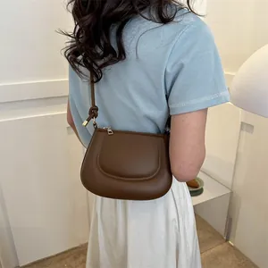 Borsa a sella marrone caffè minimalista con cuciture in rilievo e tracolla sottile