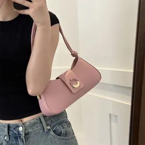 Minimalist pink leather underarm shoulder bag with golden crescent buckle on model
