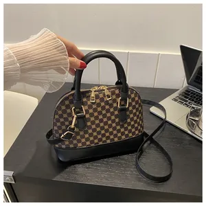 Close-up of contrast shell bag featuring geometric pattern and black leather handles