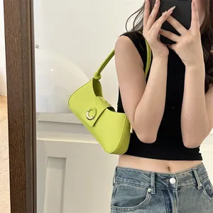 Neon green leather underarm bag with a gold ring buckle shown in a mirror selfie