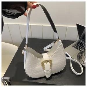 Detail of white crocodile pattern shoulder bag with ornate gold baroque buckle