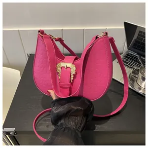 Detailed macro of magenta crescent bag featuring luxury crocodile texture and gold buckle