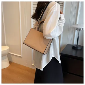 Detail of quilted beige crossbody bag with a striped strap and hand-carry handle