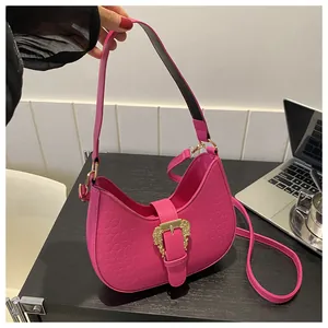 Detail of pink croc-effect hobo bag with a golden baroque-style buckle and adjustable strap