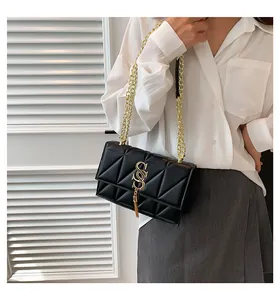 Detail of black quilted shoulder bag featuring gold double-S logo and metallic tassel