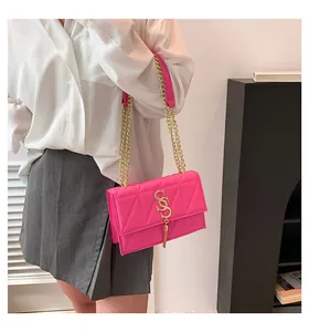 Detail shot of fuchsia quilted handbag with gold chain strap on female model