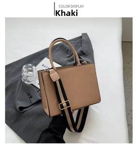 Detail of khaki square crossbody bag with quilted pattern and striped shoulder strap