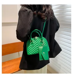Détail du sac coquillage matelassé vert avec pochette assortie et fermeture dorée