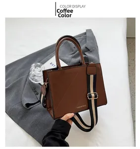 Detail of coffee brown crossbody bag with quilted pattern and striped wide shoulder strap