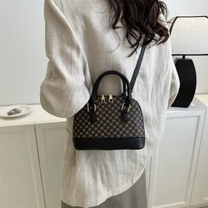 Brown printed shell shoulder bag with black handles and golden hardware in daily use