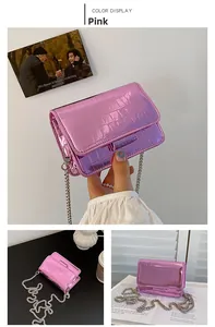 Detailed view of pink croc-embossed patent leather handbag with silver chain strap