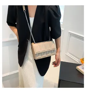 Beige gewatteerde crossbodytas met geometrische stiksels en elegante metalen ketting