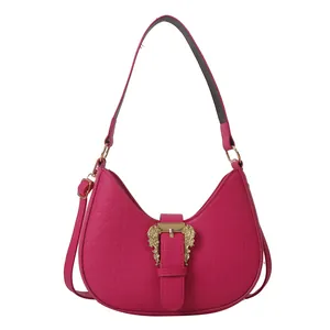Pink crocodile-embossed half-moon bag with golden baroque buckle and dual straps