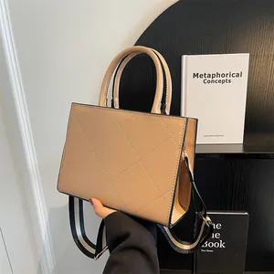 Elegant beige quilted leather handbag with wide striped shoulder strap and gold lettering
