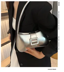 Close-up of metallic silver baguette bag with square buckle detail on shoulder