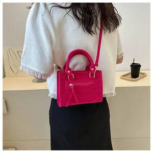 Model trägt rosarote Mini-Tragetasche mit Krokodilmuster und verstellbarem Schultergurt