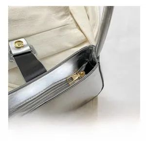 Detailed close-up of smooth gold zipper and metallic silver fabric on the shoulder bag