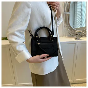 Detailaufnahme der schwarzen Kroko-Handtasche mit eleganten goldenen Beschlägen