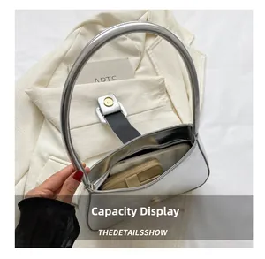 Spacious interior of silver metallic shoulder bag holding a wallet and smartphone