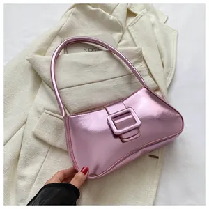 Close-up of metallic pink shoulder bag featuring a large square buckle and glossy texture