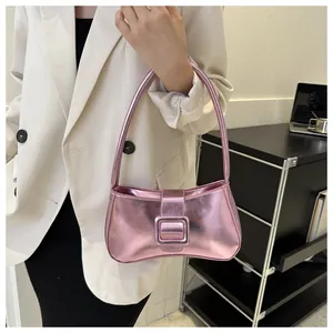 Close-up of metallic pink baguette bag with large buckle on a stylish model