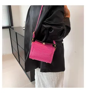 Dettaglio della piccola borsa quadrata rosa con texture a pieghe e fibbie in metallo oro