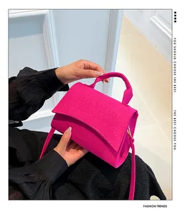 Detail of hot pink crocodile embossed felt bag with reinforced handle and thin strap