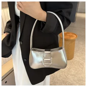 Close-up of metallic silver underarm bag featuring a stylish square buckle and glossy finish