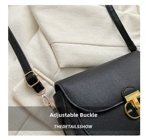 Close-up of adjustable buckle and lobster clasp on black lychee texture leather bag