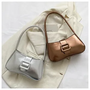 Close-up of metallic silver and bronze baguette bags with glossy finish and square buckles