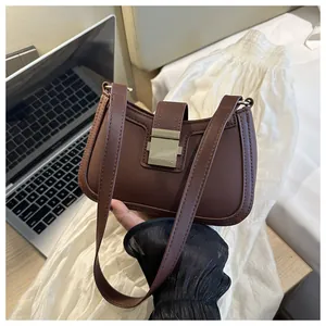 Dettaglio della borsa sottobraccio in ecopelle marrone scuro con fibbia dorata