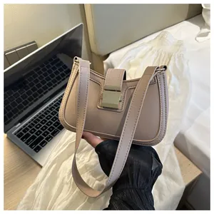Dettaglio borsa sottobraccio beige con fibbia quadrata dorata e tracolla regolabile