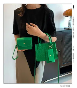 Détail de l'ensemble de sacs en feutre vert gaufré avec cabas, breloque et pochette