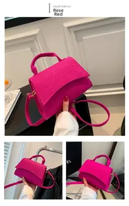 Detail view of pink crocodile embossed felt handbag with gold hardware and top handle